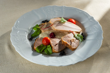 sliced snacks from boiled pork and meat on a white plate