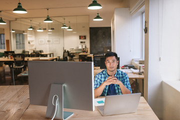 Focused young designer sitting at his workstation in an office