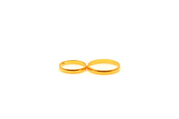 Two gold rings for a newlywed couple on a white isolated background