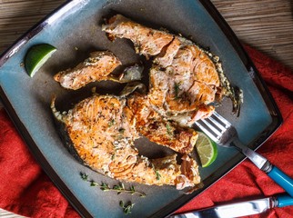 Delicious salmon steak grilled with lemon and pepper on a plate
