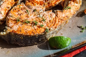 Delicious salmon steak grilled with lemon and pepper on a plate