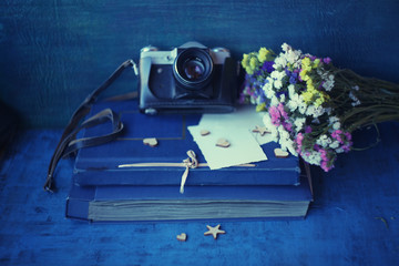Retro camera and paper photo album on wood table with flowers  - concept of remembrance and...