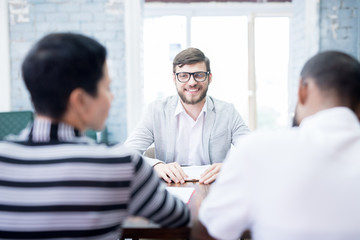 Group of business people having job interview with young man at modern office