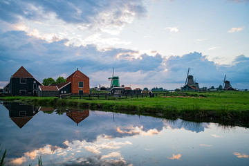 Fototapeta na wymiar De Gekroonde Poelenburg, De Kat, Windmill De Zoeker windmill with Dutch houses and reflection