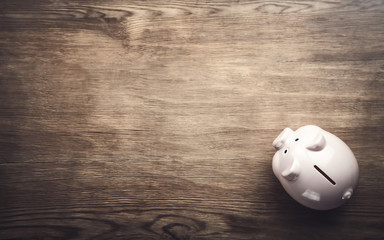 Piggy bank on wooden background. Saving money