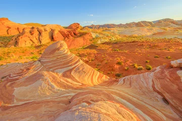 The striped landscape of popular Fire Wave Hike at Valley of Fire State Park in Nevada, United States at sunset colors. Fire Wave is one of the most iconic formations at Valley of Fire.