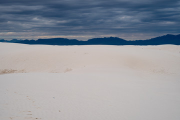 White Sands National Monument on a cloudy, overcast stormy day. Stark contrast with white gypsum sand and dark clouds