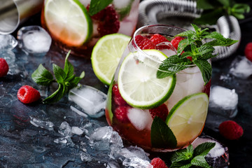 Summer cool alcoholic cocktail raspberry mojito cocktail with lime, syrup, soda, rum, mint and...