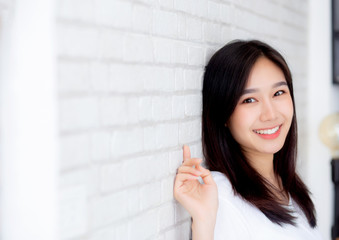 Fototapeta premium Portrait of beautiful young asian woman happiness standing on gray cement texture grunge wall brick background, businesswoman is a smiling on concrete, business people concept.