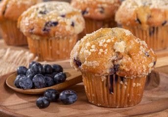 Blueberry Muffin and Spoonful of Berries on a Wooden Plate - obrazy, fototapety, plakaty
