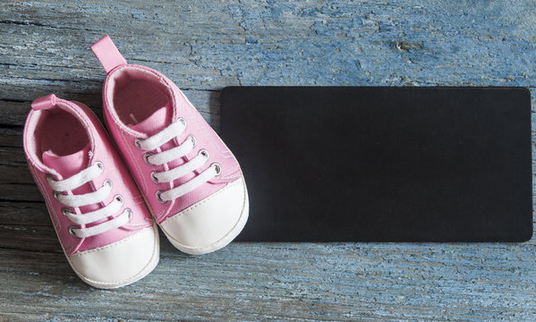 Cute little baby shoe on wood background