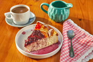 Delicious homemade cheese cake with strawberry jam and a cup of coffee