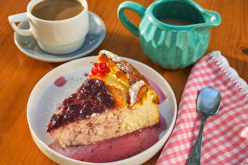 Delicious homemade cheese cake with strawberry jam and a cup of coffee