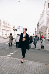 Obraz premium The girl in the black coat on the street.