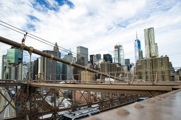 Manhattan skyline seen from the beautiful Brooklyn bridge. Cloudy day in New York City, USA.