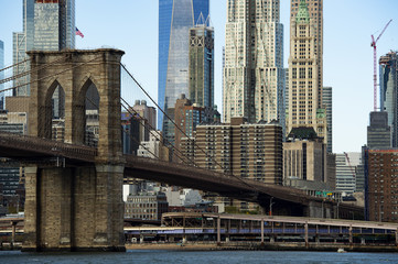 Manhattan skyline with the Brooklyn bridge and the One World Trade Center on background. Sunny day of October in New York, USA.