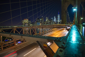 Fototapeta na wymiar Manhattan skyline at night seen from the illuminated beautiful Brooklyn bridge. New York City, USA.