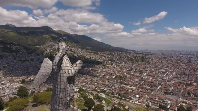 Flying behind the Statue of the Virgin overlooking Quito, Ecuador. Looking over the north of the city from the Panecillo with the Historic Centre in foreground.