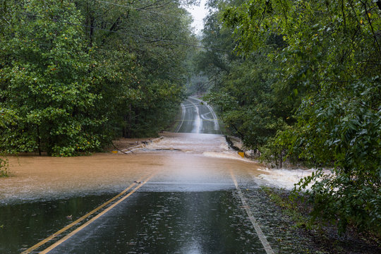Waxhaw, North Carolina - September 16, 2018: Rainwater from Hurricane Florence washes out a bridge