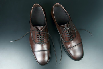 Classic men's brown Oxford shoes on dark background