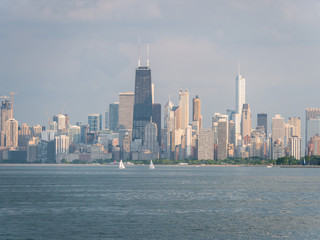 Fototapeta premium Beautiful panoramic view of the Chicago skyline with new and old skyscrapers with the calm water of Lake Michigan in the foreground.