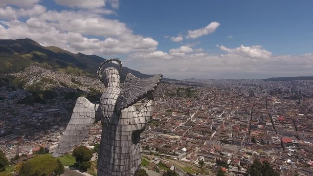 Flying behind the Statue of the Virgin overlooking Quito, Ecuador. Looking over the north of the city from the Panecillo with the Historic Centre in foreground.