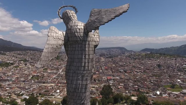 Flying behind the Statue of the Virgin overlooking Quito, Ecuador. Looking over the north of the city from the Panecillo with the Historic Centre in foreground.