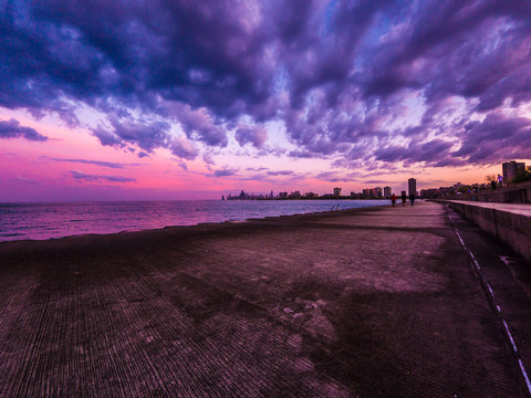 Chicago, IL - May 9th 2018: People flock to the lakefront to catch the gorgeous sunset over the Chicago skyline after earlier storm clouds drift out across the water.