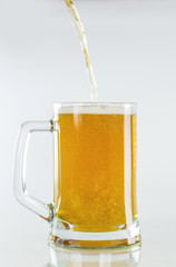 Beer is poured in a glass on an isolated whitebackground Oktoberfest celebration.