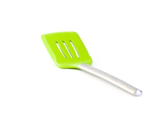Closeup of a bright neon green silicone spatula burger flipper with stainless steel handle isolated on a white background.