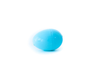 A closeup photograph of a single light blue plastic Easter egg that comes apart for toys, candy or money during egg hunts isolated on a white background with open space around it.