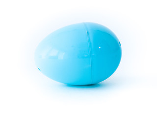 A closeup photograph of a single light blue plastic Easter egg that comes apart for toys, candy or money during egg hunts isolated on a white background with open space around it.