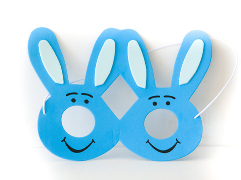 Cute photograph of a child's dark and light blue Easter bunny mask with ears isolated on a white background making a great holiday background.