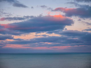 Beautiful vivid pink and blue clouds over the blue water of Lake Michigan at sunset making a wonderful background image or wallpaper.