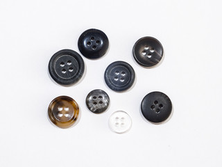 Close up view of several four hole sewing or clothing buttons of random shape color and size...