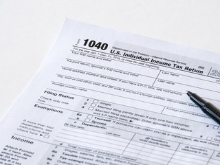 Close up photograph of United States 1040 individual income tax return form with a black ballpoint pen perfect for tax day or tax season background or wallpaper image. - obrazy, fototapety, plakaty