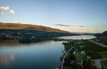 Aerial panoramic view of a small town, Oyama, during a vibrant summer sunset. Located near Kelowna and Vernon, BC, Canada.