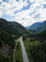 Aerial view of a scenic road going through the valley surrounded by the Beautiful Canadian Mountains. Located between Hope and Princeton, BC, Canada.