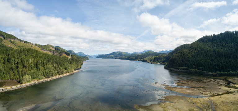 Aerial panoramic landscape view of an Ocean Inlet surrounded by mountains during a vibrant sunny summer day. Taken near Holberg, Northern Vancouver Island, BC, Canada.