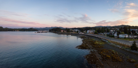Fototapeta premium Aerial panoramic view of a small town, Port Hardy, during a cloudy summer sunset. Located in Northern Vancouver Island, BC, Canada.