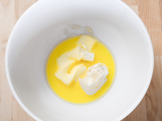 Photo of ingredients in a  bowl including yellow butter for baking Christmas holiday oatmeal raisin cookies