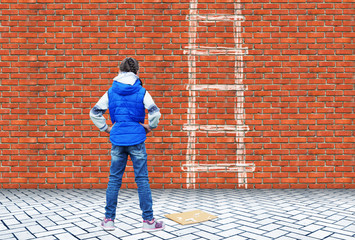 Little girl drew with chalk on a brick wall the ladder to overcome this wall as a obstacle