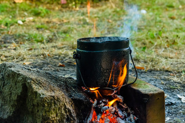 Cooking food in a kettle on bonfire