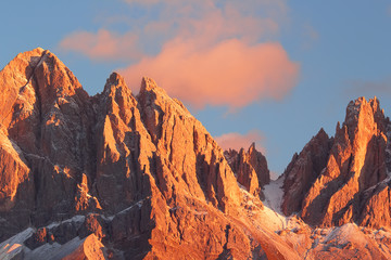 Beautiful mountain peaks covered by colored clouds at sunset, mountain landscape background