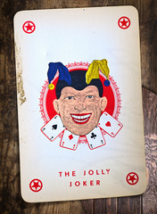 Old fashioned background with vintage Jolly Joker playing card