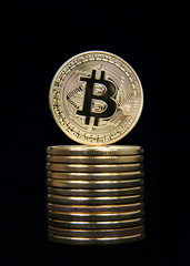 Digital Cryptocurrency currency. Golden bitcoin coin stacked and isolated on black background. Physical bit coins