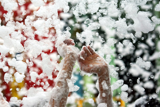 raised hands of a man in a foam disco
