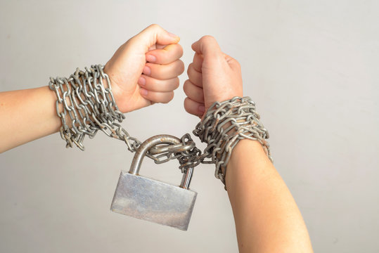 Woman hands in a steel chains isolated on white