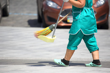 janitor cleans the sidewalk of the city