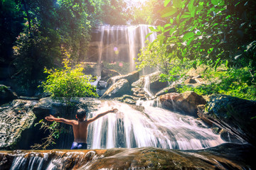 Boy playing waterfall in the forest at Soo Da Cave Roi et Thailand